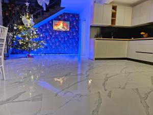 a living room with a christmas tree and a kitchen at Vibe House Madisson in Braşov