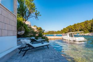a couple of chairs sitting on a patio next to the water at Apartman Mirakul 2 in Korčula