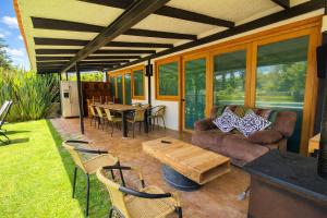 a screened in porch with a couch and a table at Bungalow con alberca Privada y Climatizada en Tequisquiapan in Tequisquiapan