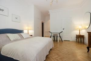 a white bedroom with a bed and a table at Sienna Central Studio & Parking in Warsaw