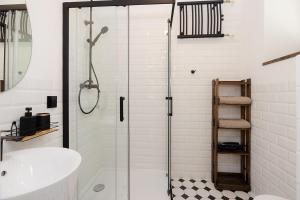 a bathroom with a glass shower and a sink at Sienna Central Studio & Parking in Warsaw