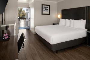 a hotel room with a large bed and a balcony at Sand Castle Inn in Seaside