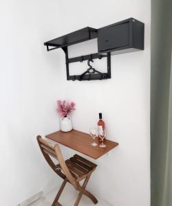 a wall mounted desk with a wine bottle and glasses at Kato Yialos Paros in Parikia
