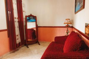 a living room with a red couch and a mirror at Casa Palagui Colonial in Valladolid