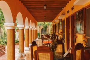 an outdoor patio with a table and chairs at Casa Palagui Colonial in Valladolid