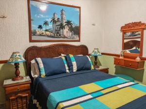 a bedroom with a bed and a painting on the wall at Casa Palagui Colonial in Valladolid