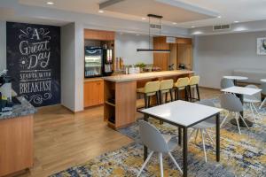 a restaurant with a bar and tables and chairs at TownePlace Suites Redding in Redding