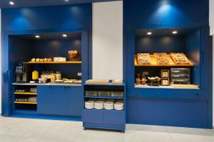a bakery with blue walls and shelves of food at Four Points Flex by Sheraton Madrid Atocha in Madrid