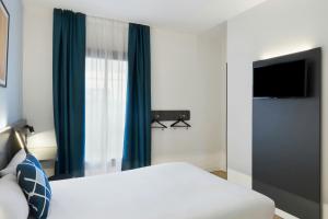 a hotel room with a bed and a television at Four Points Flex by Sheraton Madrid Atocha in Madrid