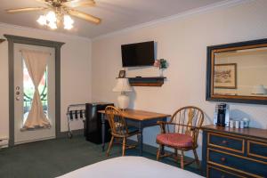 a hotel room with a desk and a table with chairs at Auberge Lakeview Inn in Lac-Brome