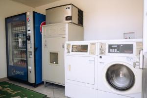 a washer and dryer next to a drink machine at Sand Castle Inn in Seaside