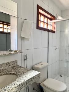 a white bathroom with a toilet and a sink at Estalagem do Carmo in Pirenópolis +8 photos