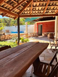 a large wooden table under a wooden roof at Estalagem do Carmo in Pirenópolis