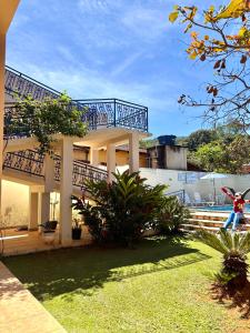 a large house with a balcony and a yard at Estalagem do Carmo in Pirenópolis