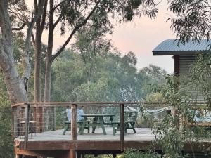 a wooden deck with a picnic table and a cabin at The Odd Frog in Bright +35 photos