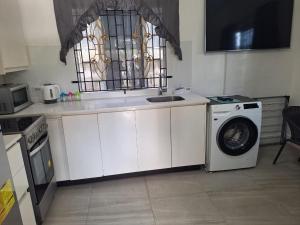 a kitchen with a sink and a washing machine at 14 Zeneith Avenue in Harbour View