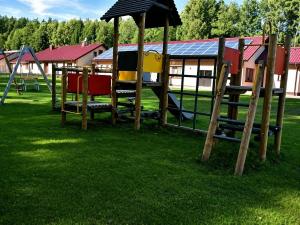 a playground with a slide and an umbrella at Gościniec nad Dobrzycą in Wałcz