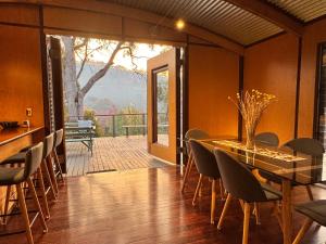 a dining room with a table and chairs and a balcony at The Odd Frog in Bright
