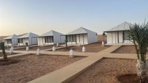 a row of houses in the middle of a desert at Camp Merzouga Sand Explorer in Merzouga