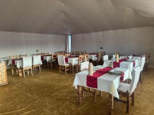 a dining room with tables and chairs in a tent at Camp Merzouga Sand Explorer in Merzouga