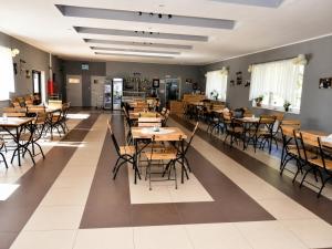 a restaurant with tables and chairs in a room at Gościniec nad Dobrzycą in Wałcz +15 photos