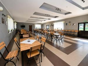 a restaurant with tables and chairs in a room at Gościniec nad Dobrzycą in Wałcz