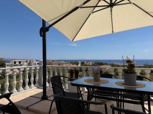 a table and chairs with an umbrella on a balcony at Villa Dreamy View in Agia Ermioni