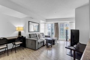 a living room with a couch and a desk at The Pantages Suites in Toronto