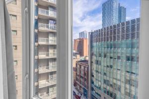 a view of a city skyline from a window at The Pantages Suites in Toronto