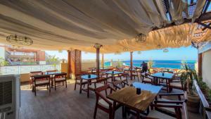 a restaurant with tables and chairs and a view of the ocean at Swiss Wellness Hotel Suites in Hurghada