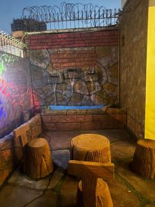 two logs and two stools in front of a wall at Seaview lodge Executive in Karachi