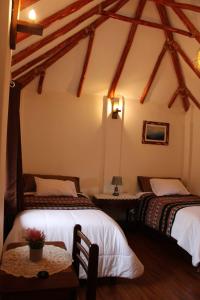 a bedroom with two beds and a table in a room at Terra Alta Lodge in Yanque