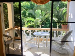 a balcony with chairs and a table on a porch at Cita del Sol City Apartments in Cabarete