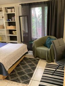 a bedroom with a bed and a chair and a window at Maisonnette Nantes in Nantes