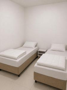 two beds sitting next to each other in a room at Heyco camping e hospedaria in Cabo Frio