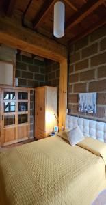 ein großes Bett in einem Zimmer mit einer Backsteinwand in der Unterkunft Wulkan Studio in Amecameca de Juárez