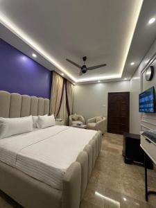 a bedroom with a large bed and a flat screen tv at Seaview lodge Executive in Karachi