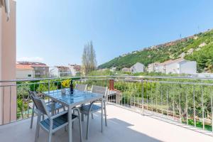 a patio with a table and chairs on a balcony at Apartments Mir in Duće