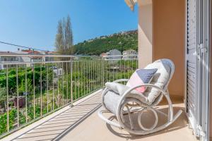 a chair on a balcony with a view at Apartments Mir in Duće