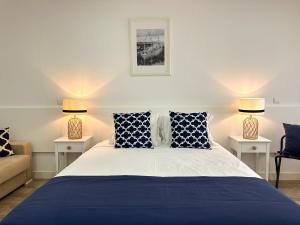 a bedroom with a blue and white bed and two lamps at Pátio 29 - Guest House in Viana do Castelo