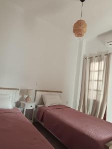 a bedroom with two beds and a window at Korali in Symi