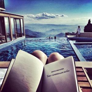 a swimming pool with a book in the water at SM Apartments Kopaonik in Kopaonik