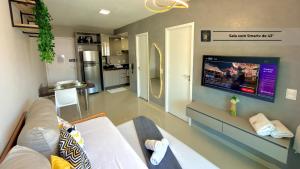 a living room with a couch and a flat screen tv at Vg Fun by Diego Flats in Fortaleza