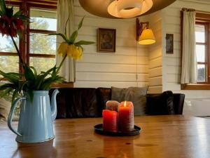 a table with two candles and a vase on it at Beachclose Log Cabin On Mors With A View in Nykøbing Mors