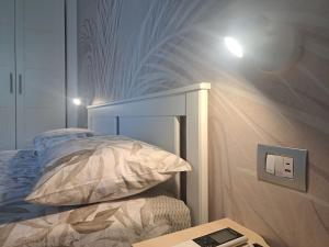 a bedroom with a bed with a light on the wall at Brezza d'amare a lovely accommodation in Anzio in Anzio