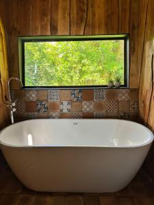 a large white bath tub in a bathroom with a window at Poas Green Chalets in Fraijanes +46 photos