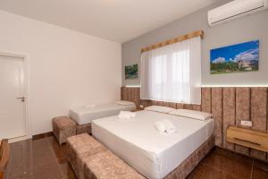 a bedroom with two beds and a couch at Hotel Shkodra Comfort in Shkodër
