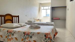 a bedroom with two beds and a window at Hotel Polonini in Piúma +31 photos