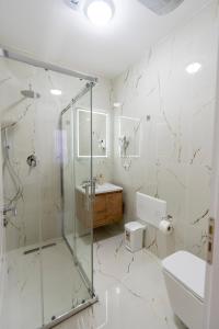 a bathroom with a shower and a toilet and a sink at Hotel Shkodra Comfort in Shkodër +64 photos