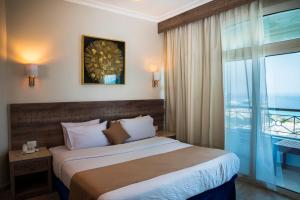 a hotel room with a bed and a large window at Swiss Wellness Hotel Suites in Hurghada
